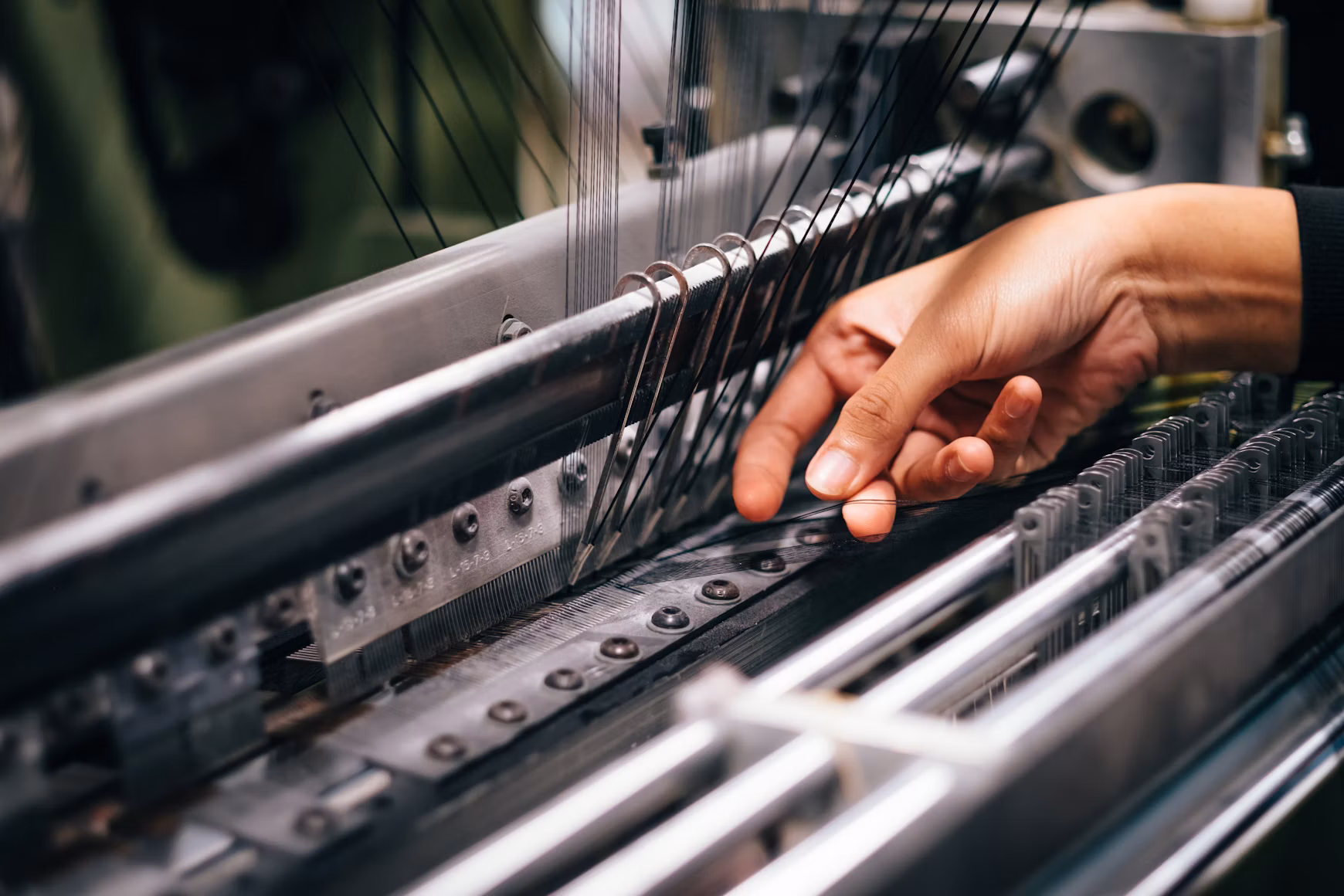 An operator at a spinning frame — knowledge held in hands rather than manuals.
